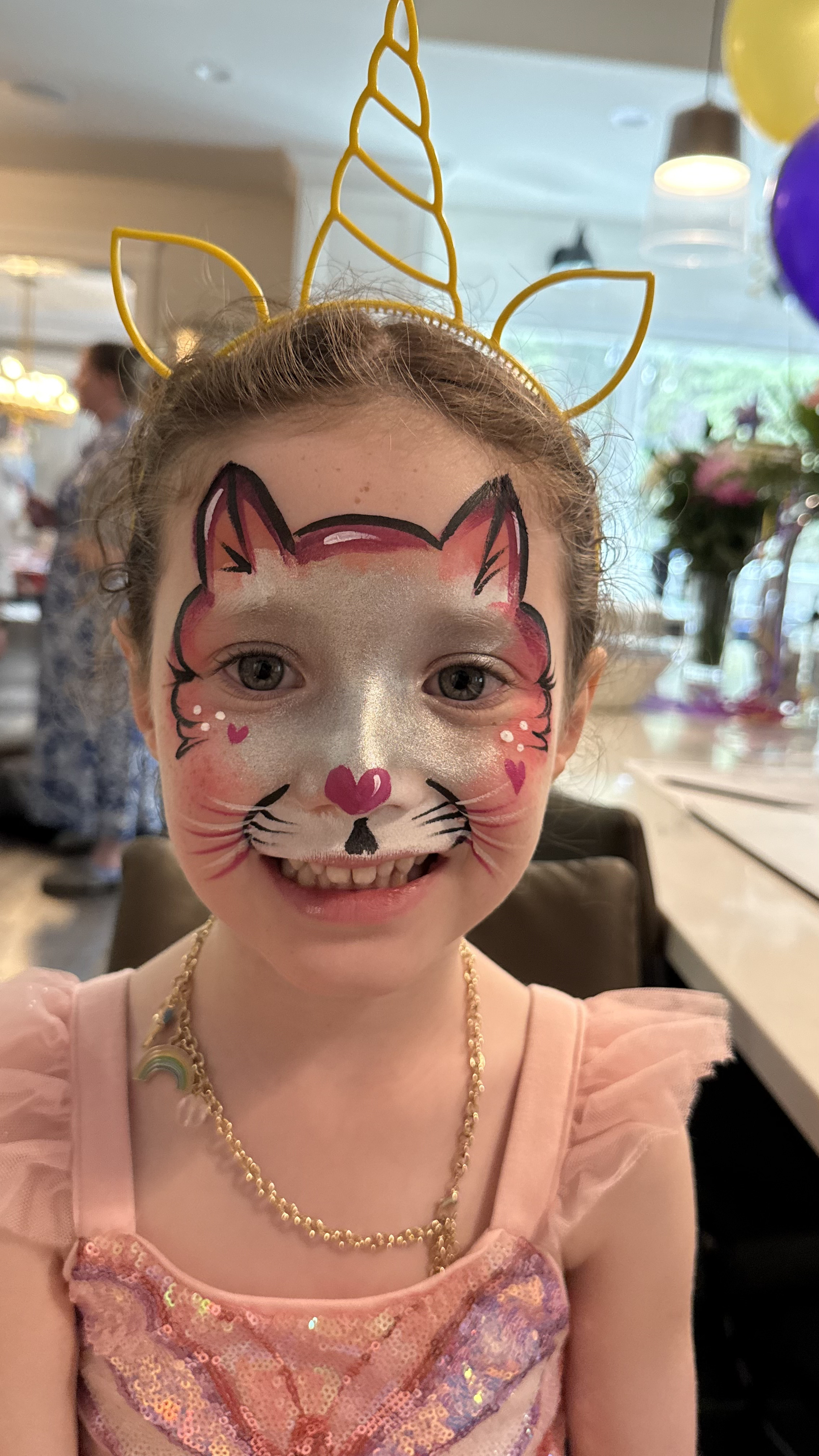 Happy child with beautiful cat/unicorn face painting